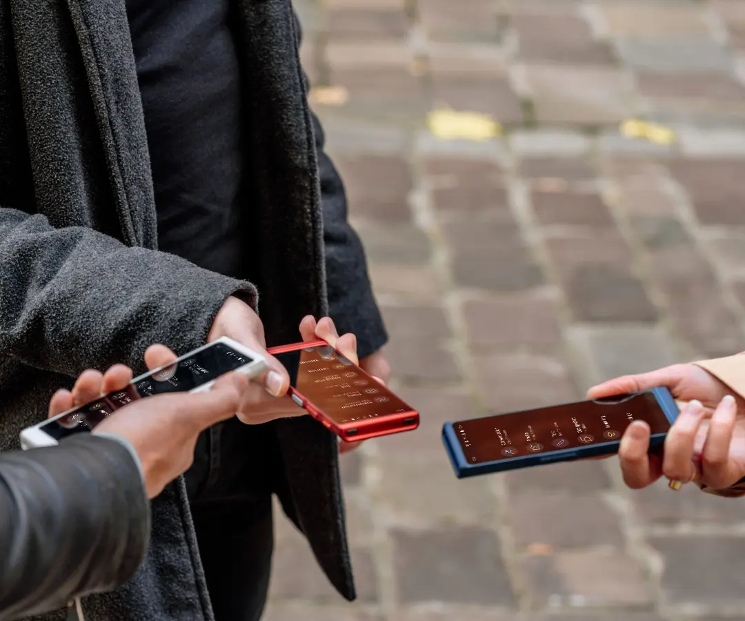 Trys draugai, laimingi laikydami savo vertėjus, kalbasi ir dalijasi akimirkomis kartu. 